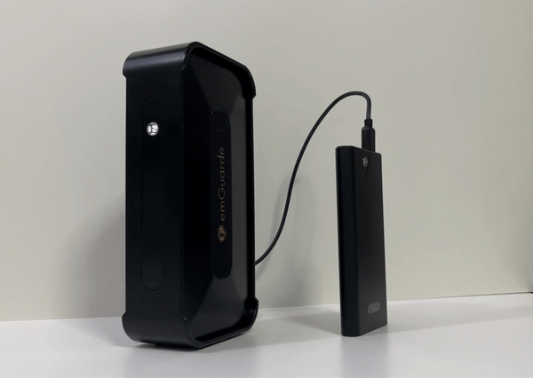 emGuarde plugged into a portable power bank — works anywhere